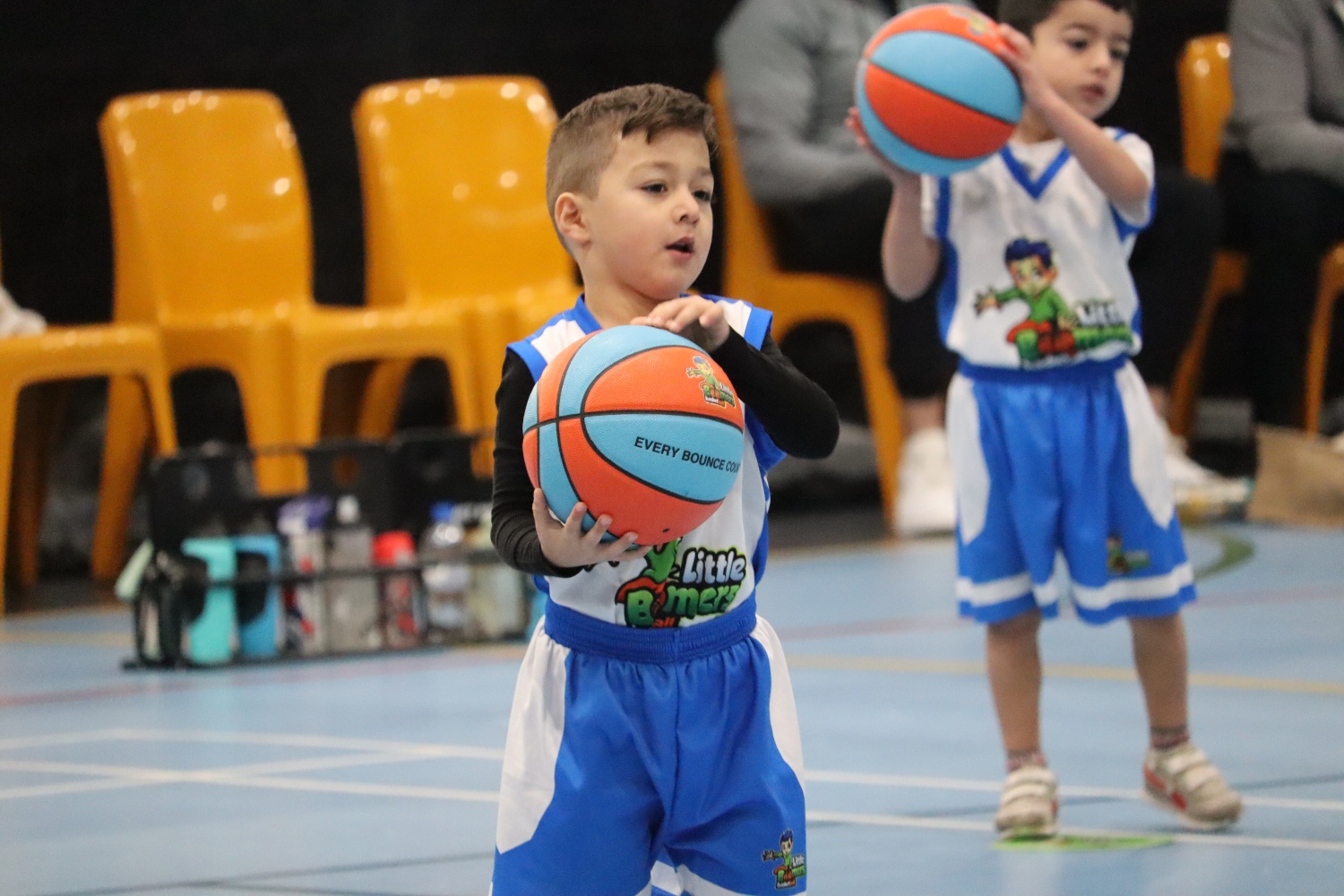 young boys in blue and white uniforms are holding basketballs, ready to play on the court